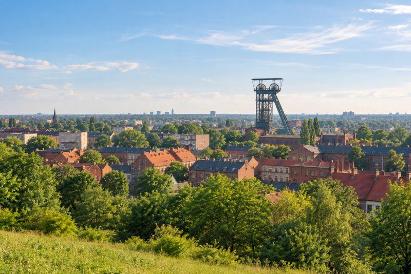 Śląski pejzaż: miasto z dawną wieżą szybową i zieleń